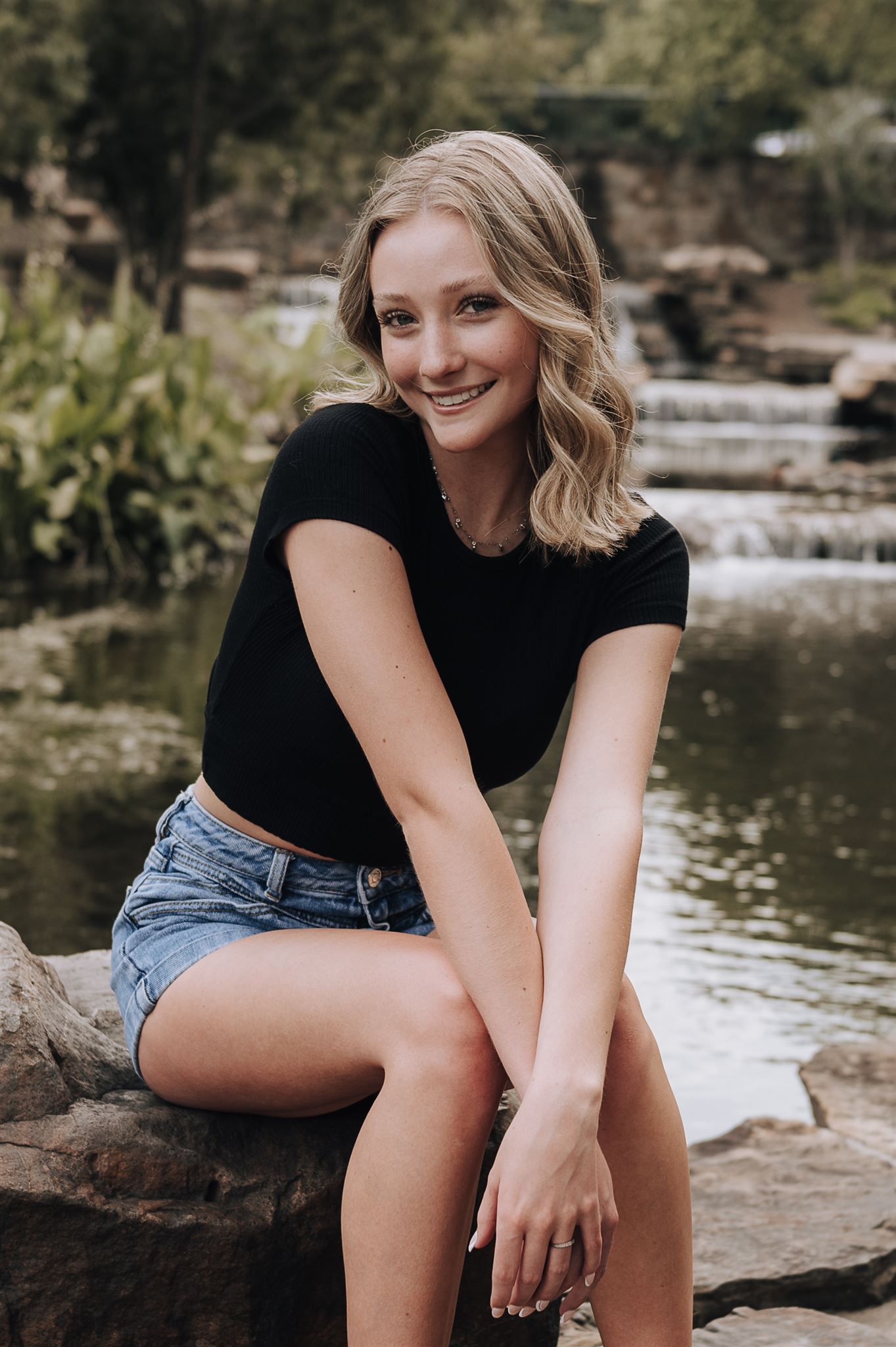 A relaxed outdoor portrait by a cascading water feature.