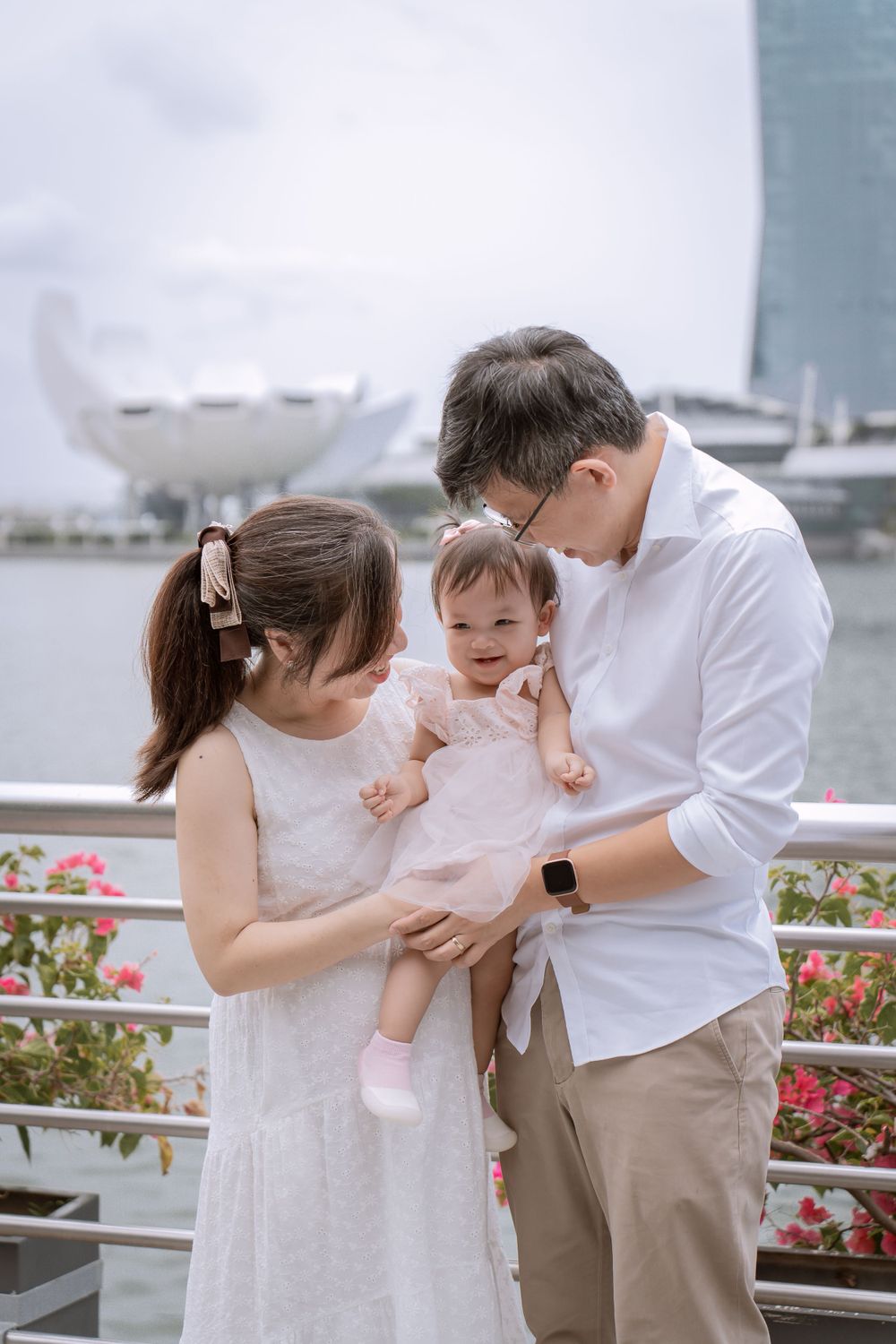 Family shares intimate moment with baby at Singapore's Marina Bay waterfront.