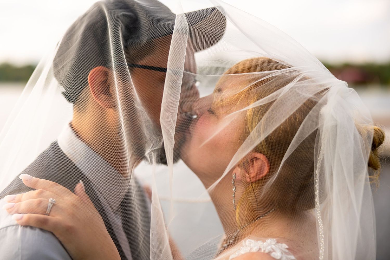 Close-up romantic moment between couple under wedding veil.
