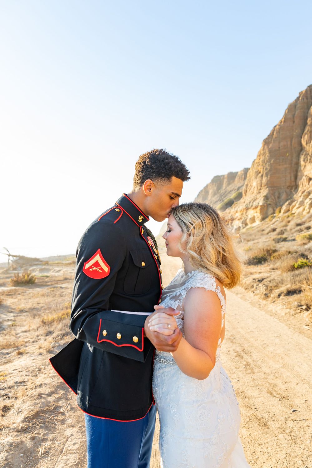A Marine and his bride share an intimate moment during their sunset desert wedding photoshoot.