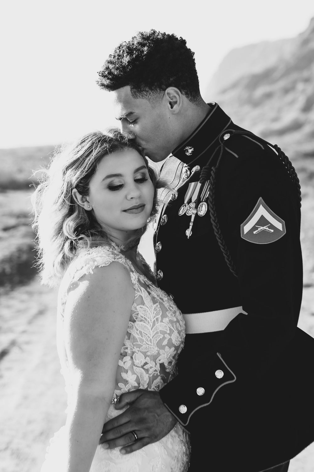 A black and white wedding portrait capturing a tender moment between newlyweds.