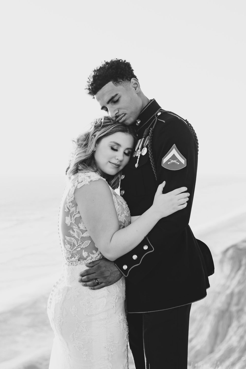 Black and white intimate portrait of military couple embracing on their wedding day.