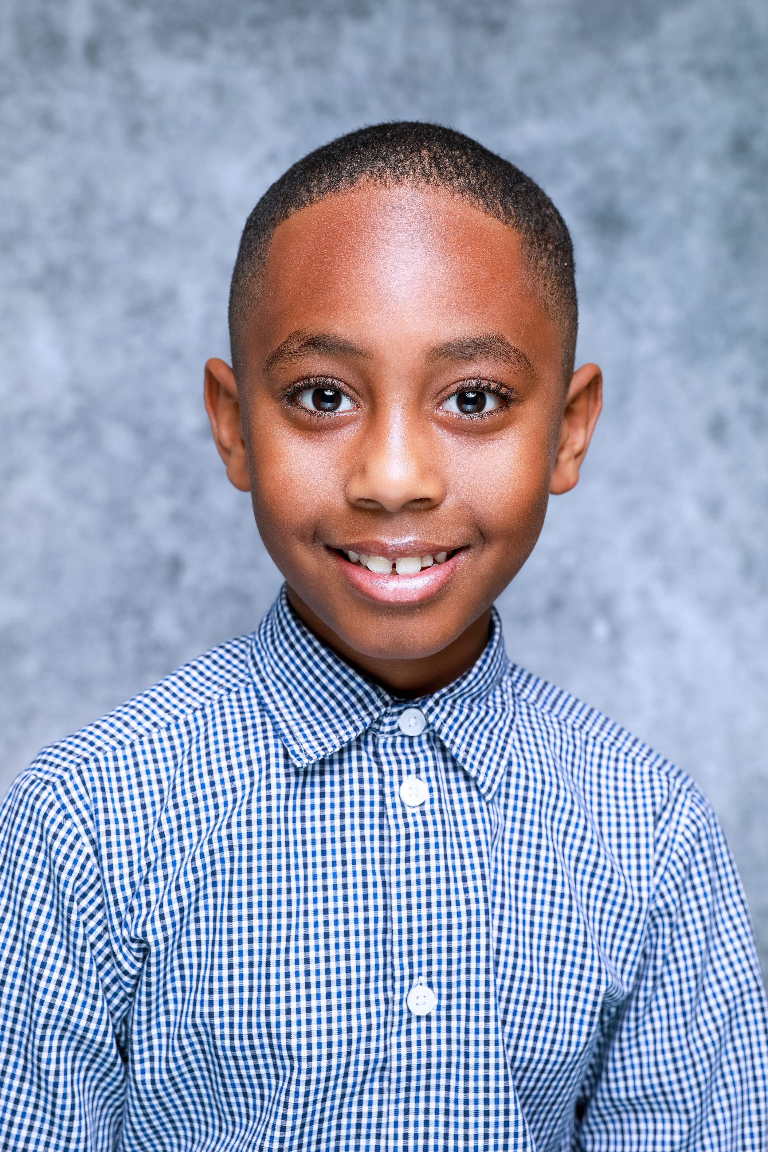 School portrait of young student in blue gingham button-down shirt.