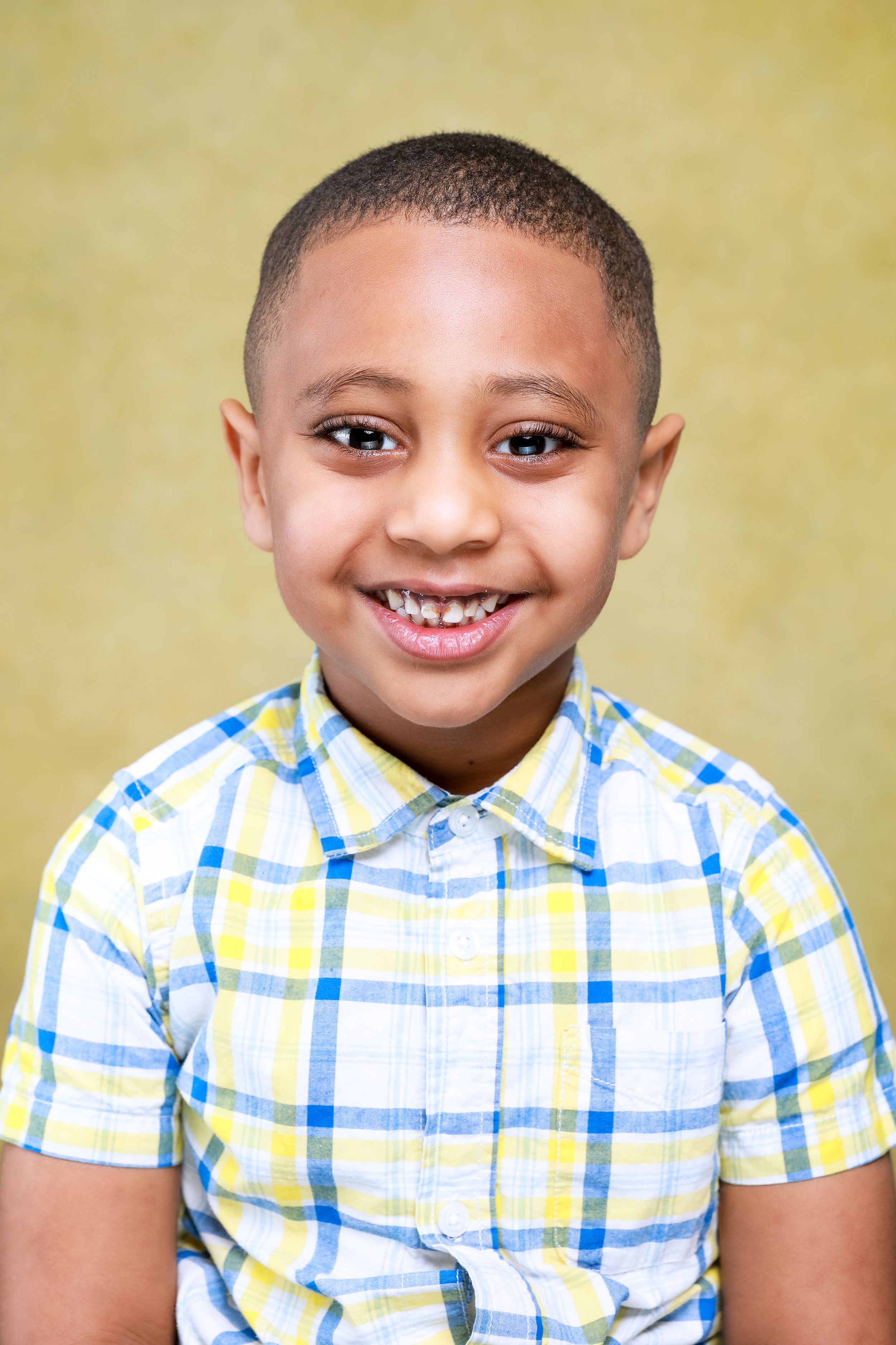 Portrait of young student wearing yellow and blue plaid short-sleeve button-down shirt.
