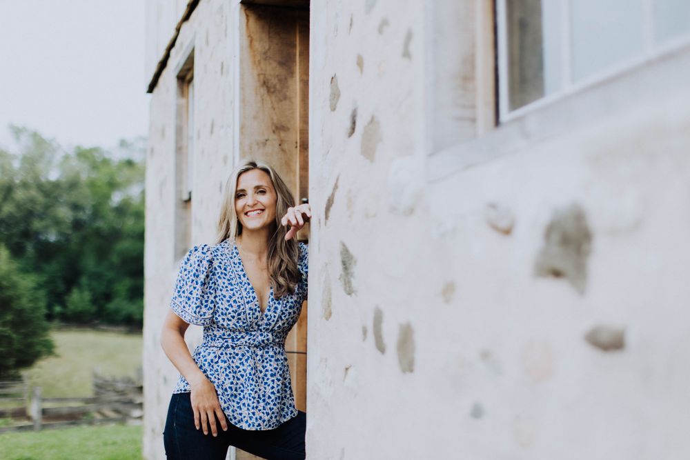 Outdoor portrait session against white wall with natural lighting.