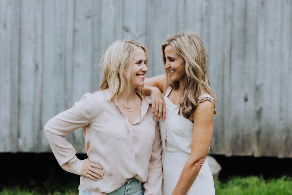 Two people sharing joyful moment together against wooden wall background.