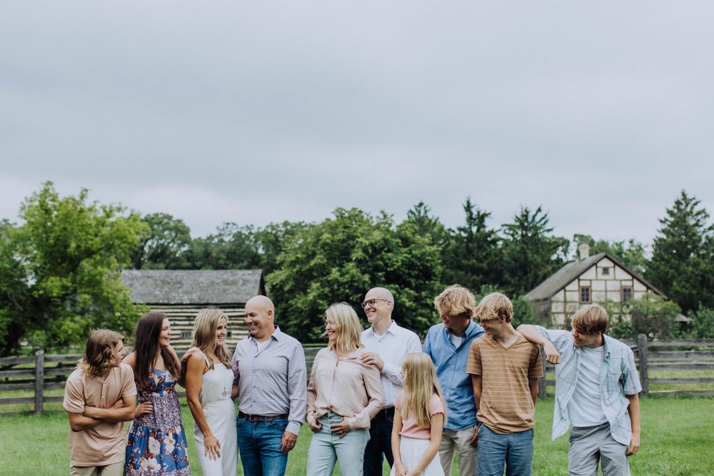 Large group photo taken outdoors at rustic farm setting.