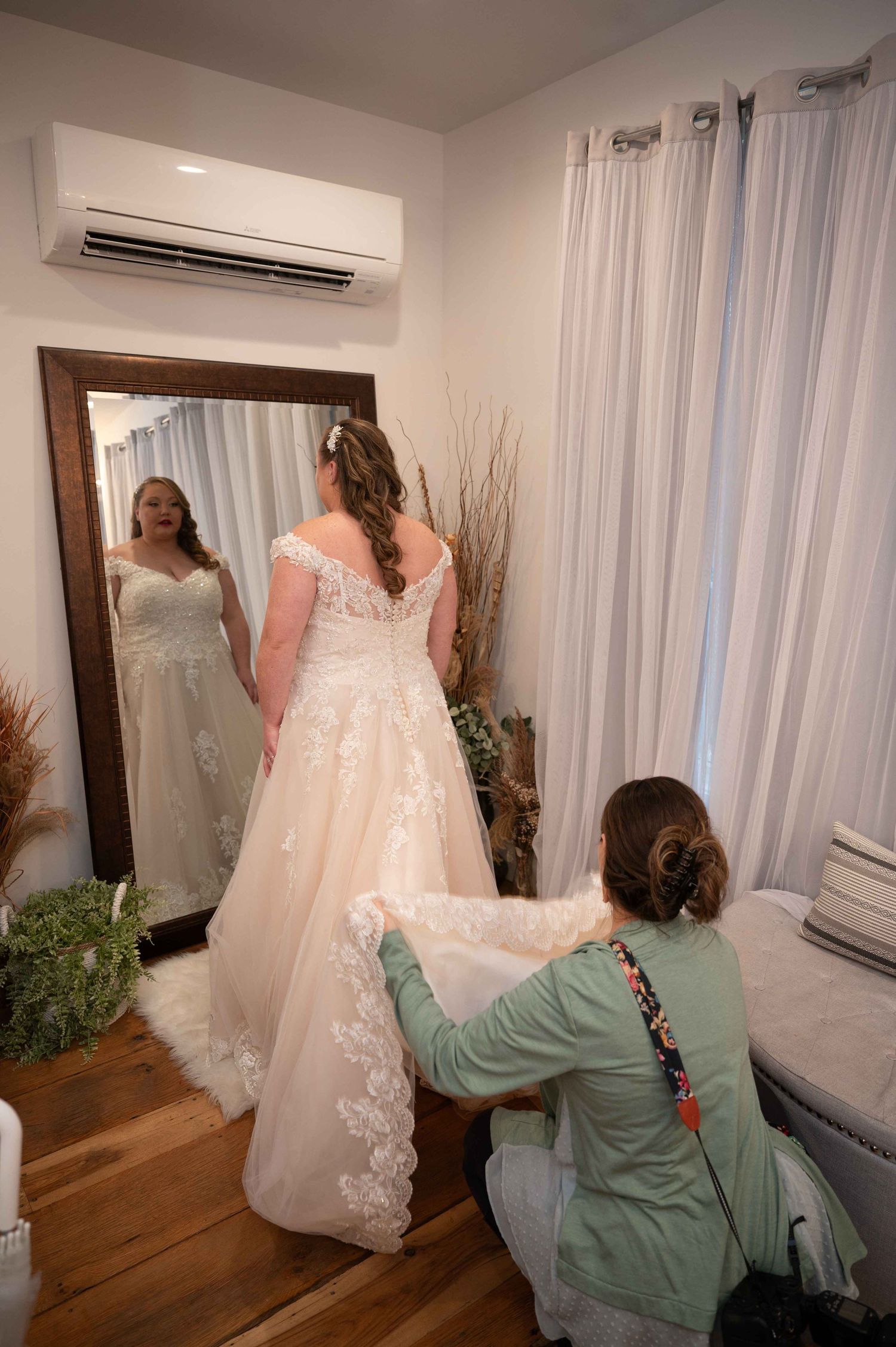 A wedding dress fitting session shows the final adjustments being made in a bridal suite.