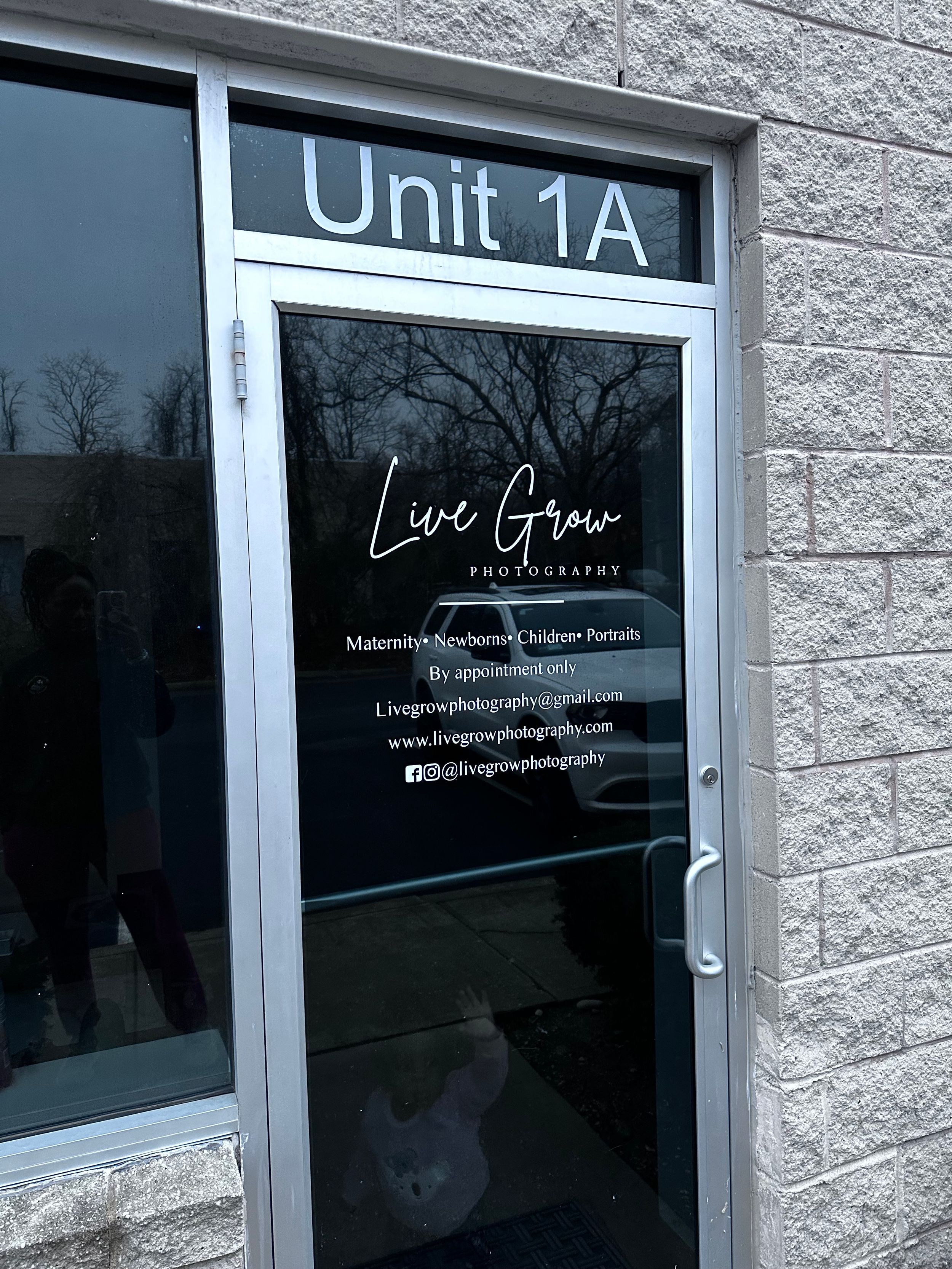 Photography studio entrance with Live Grow branding on glass door.
