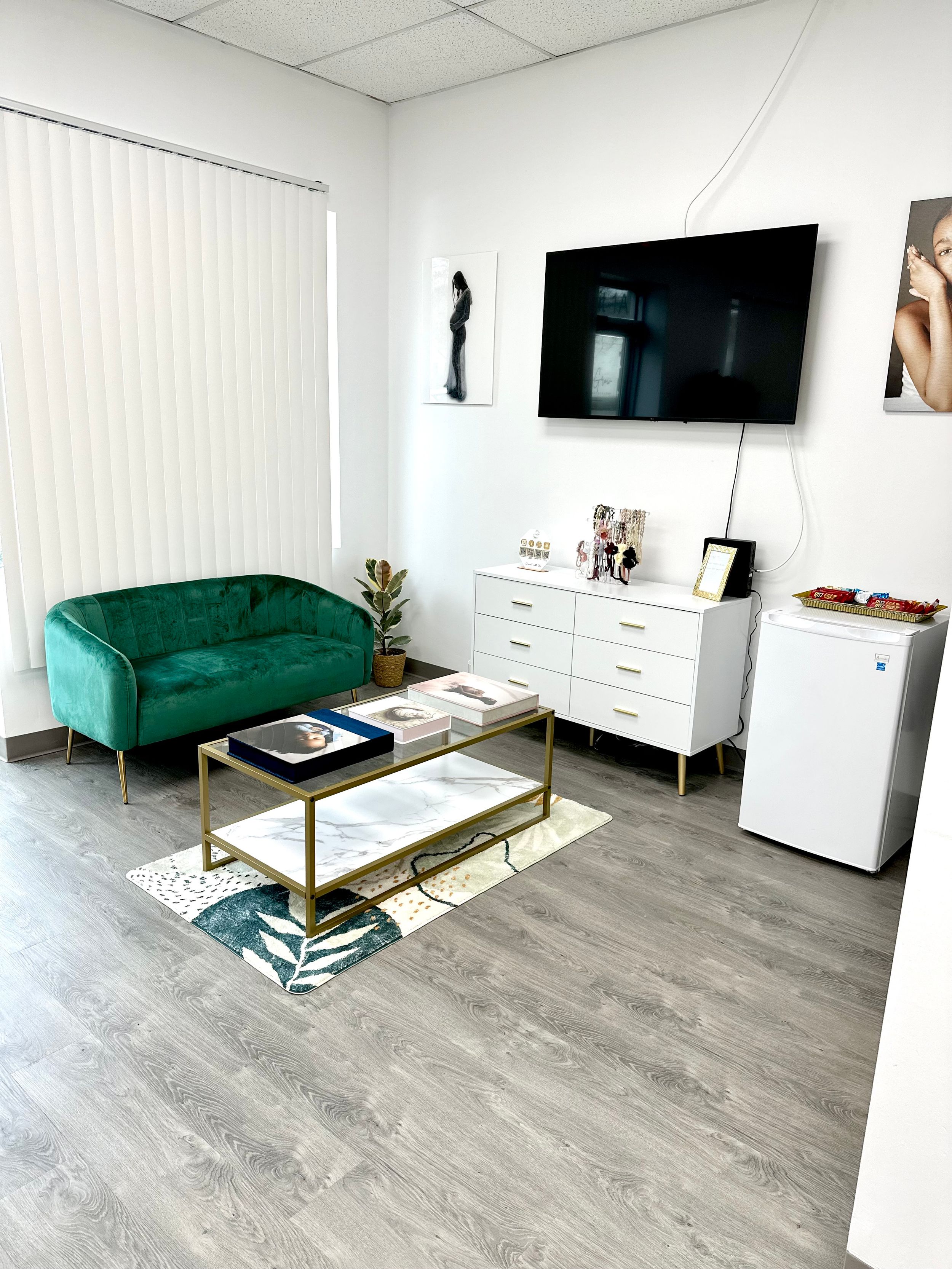 Modern studio lounge with emerald velvet sofa and gold accented furniture.
