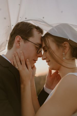 Intimate close-up of a tender moment between newlyweds at sunset.