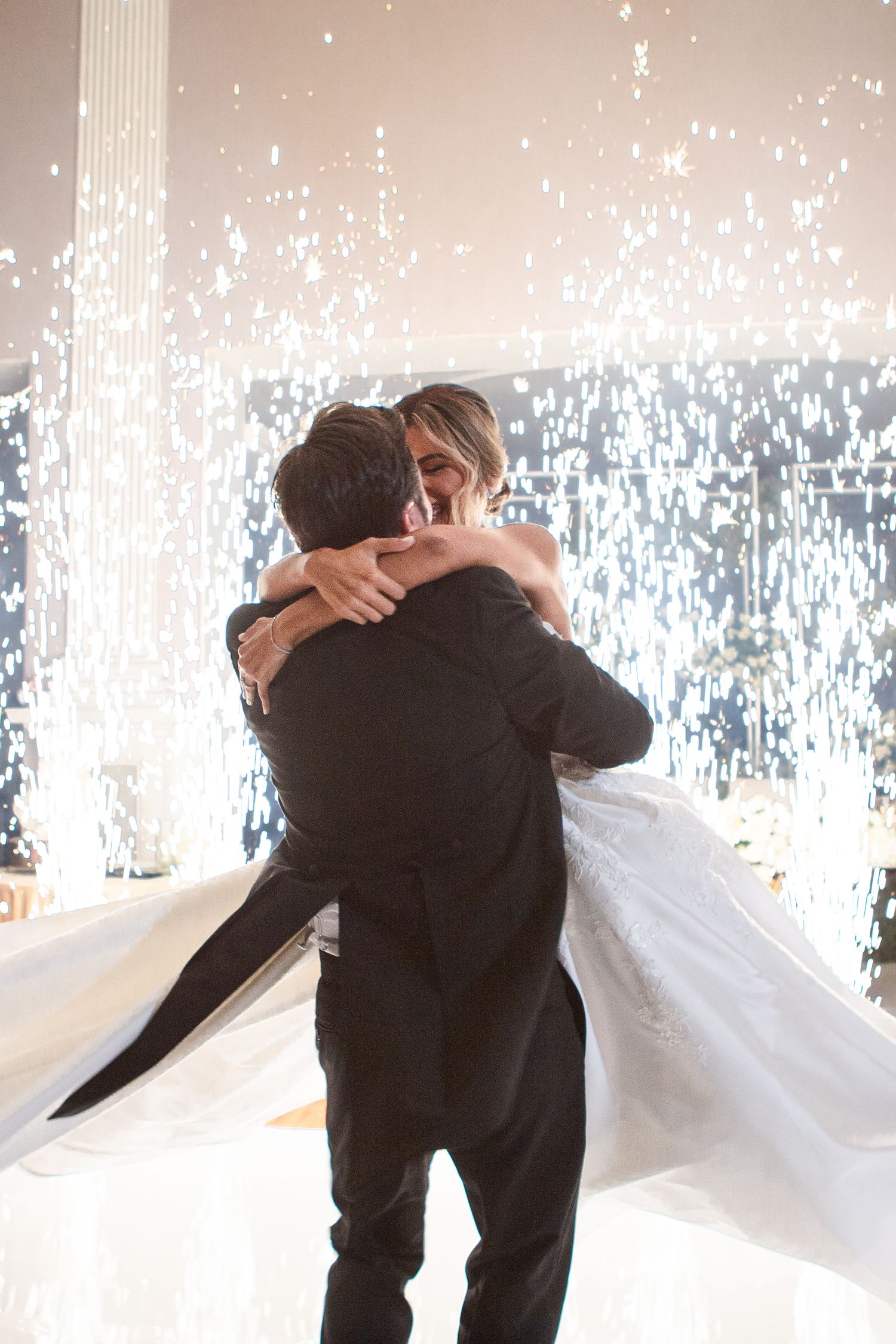 A romantic first dance moment with indoor firework effects creating a magical atmosphere.