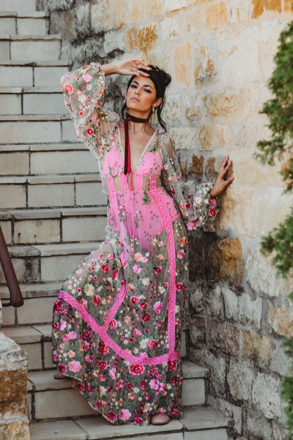 Fashion photography series showing a pink floral dress against a weathered stone wall backdrop.