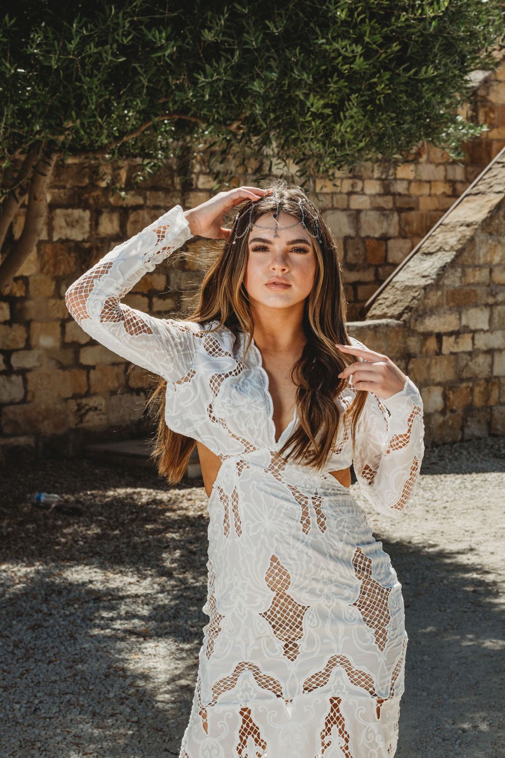 A boho-style photoshoot featuring a white lace coverup in natural sunlight.