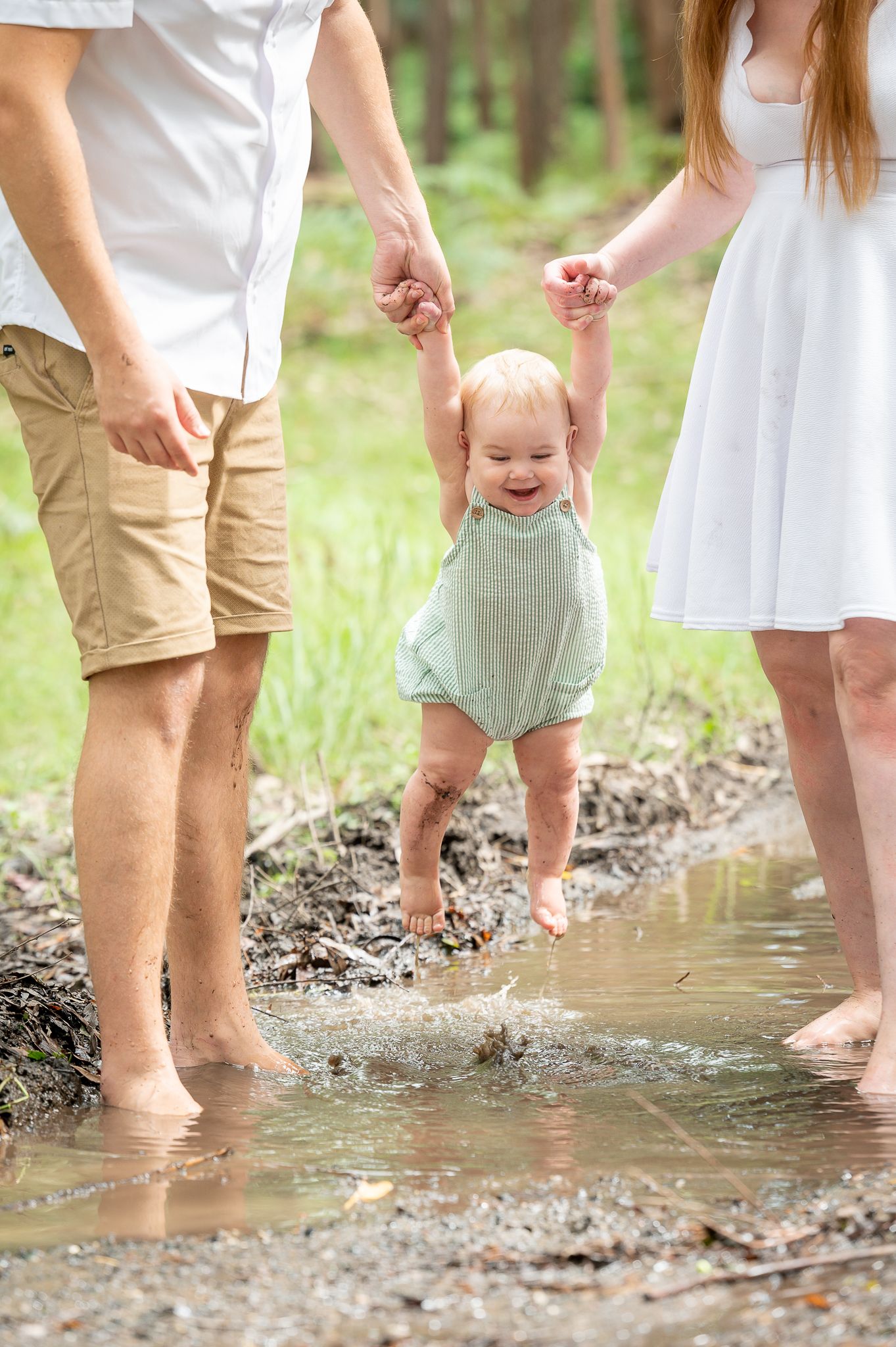 family playing in a mud puddle