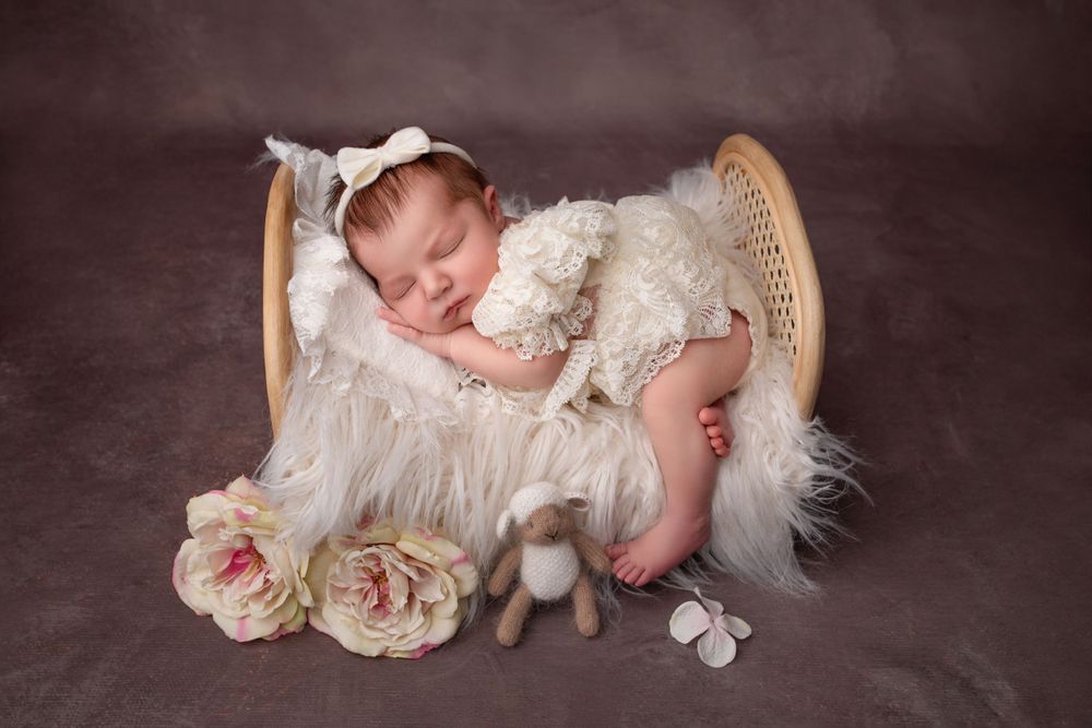 newborn baby girl sleeping on bed in white dress West Midlands
