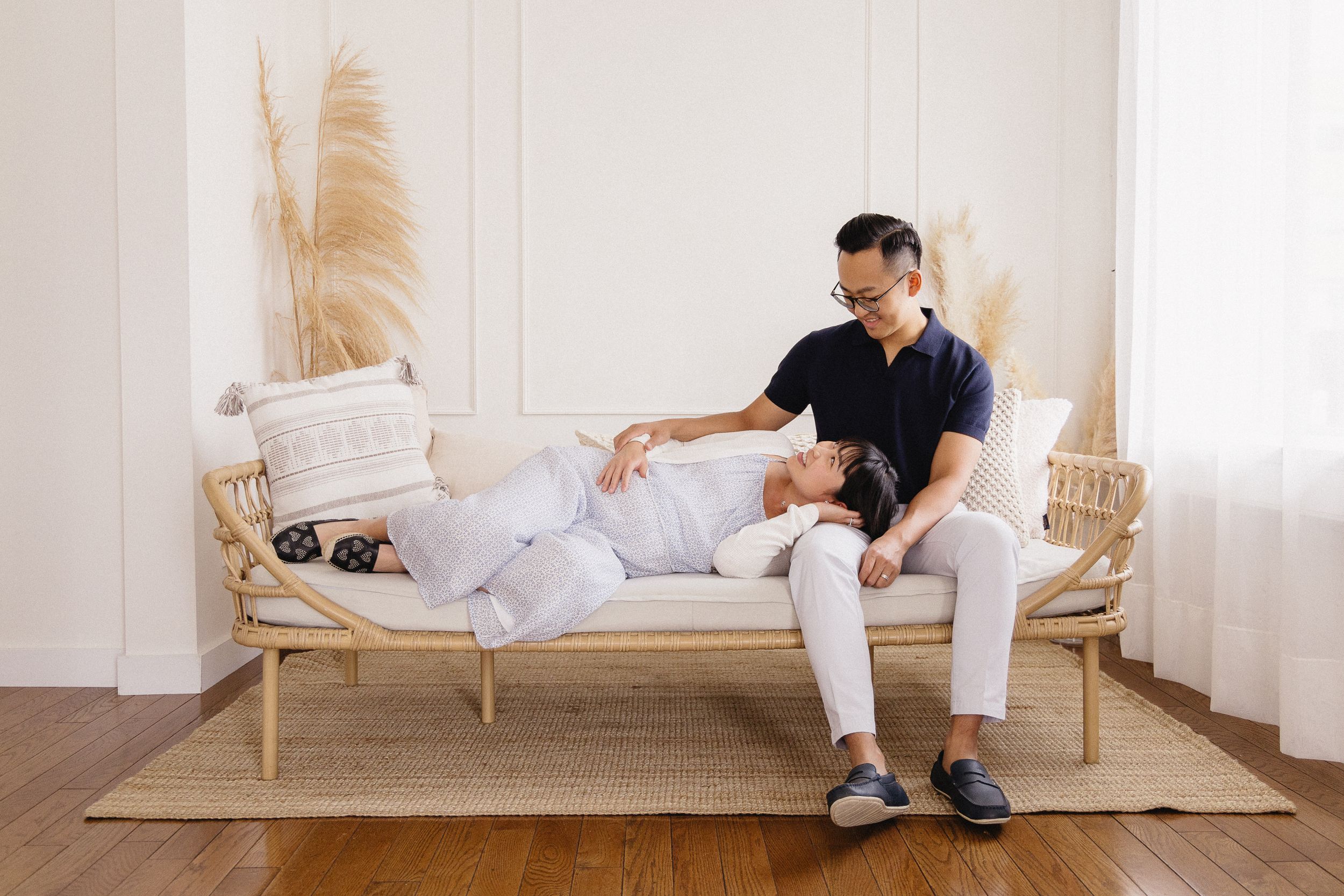 Couple sharing tender moments in bright, modern bedroom setting.