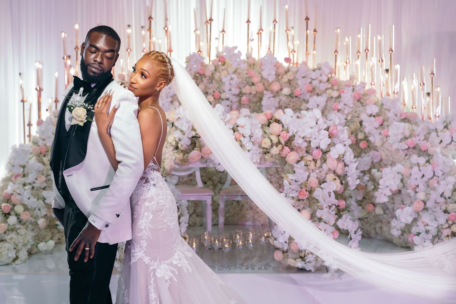 Elegant wedding ceremony setup with floating candles and pink floral arrangements creating dreamy atmosphere.