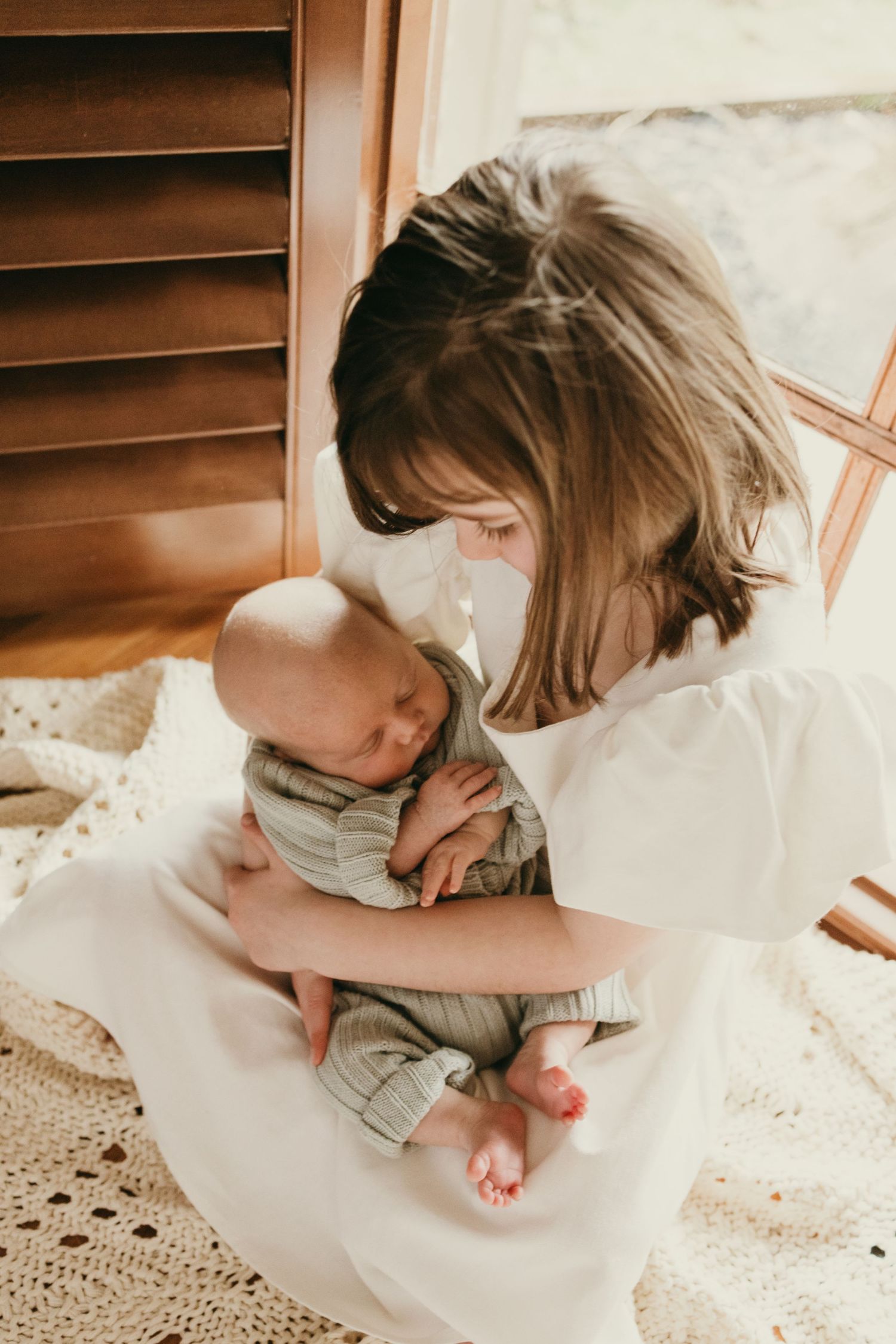 Intimate moment with sleeping baby in gray knit outfit resting peacefully.