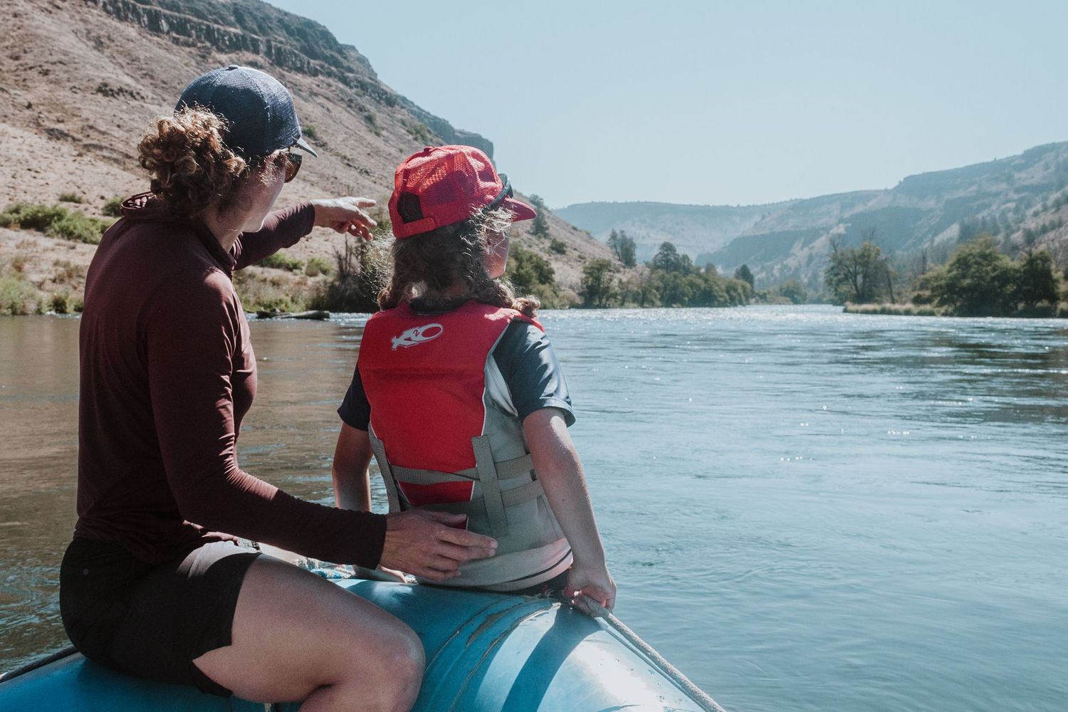mother looking ahead down river with daughter