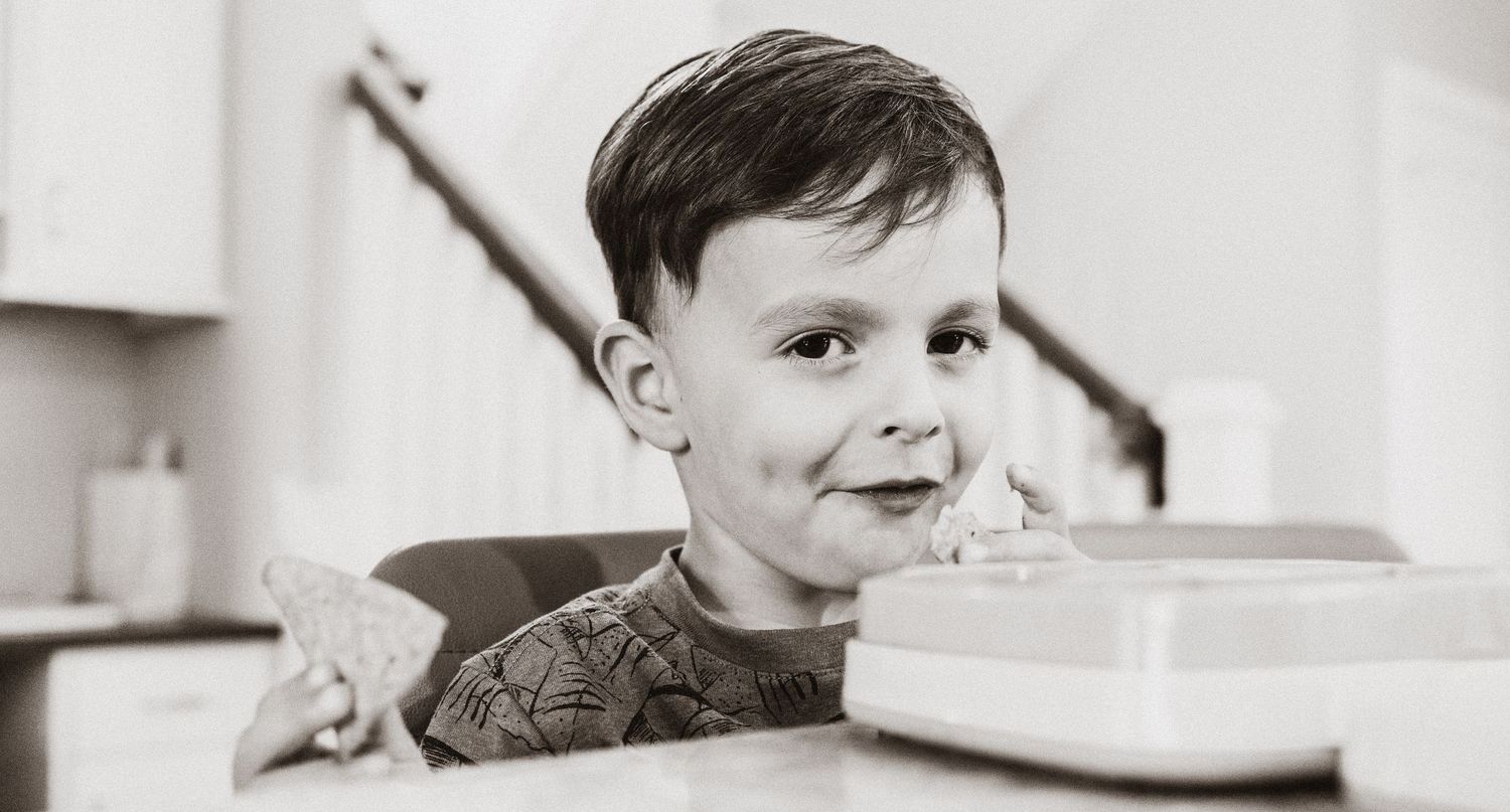 boy with mischievous grin eating breakfast