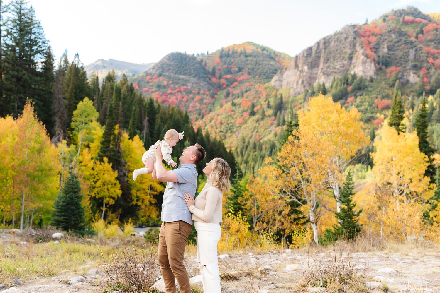 Engagement photos in mountain setting with dramatic fall colors and evergreen trees.