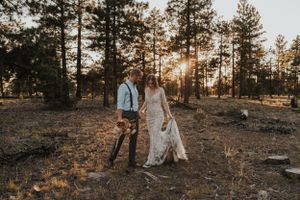 Sunset wedding photography session among tall pine trees in a mountain forest setting.