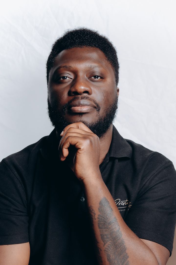 Professional studio portrait of person in black polo shirt against white background.