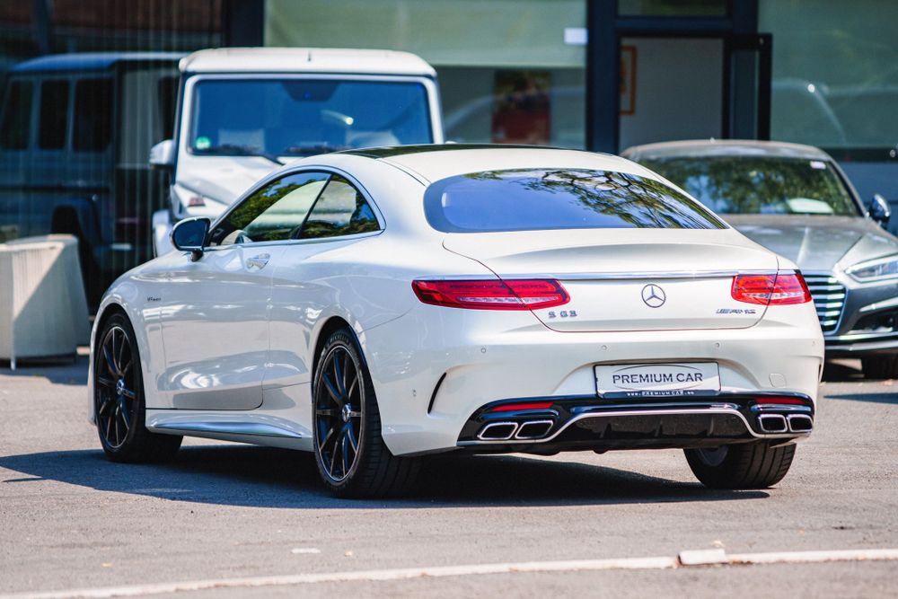 White Mercedes-Benz S-Class Coupe with sport styling and distinctive taillights parked in a lot.