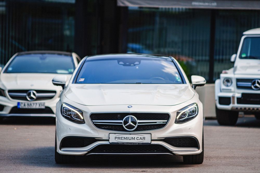 Front view of a white Mercedes-Benz S-Class Coupe showcasing iconic grille and LED headlights.