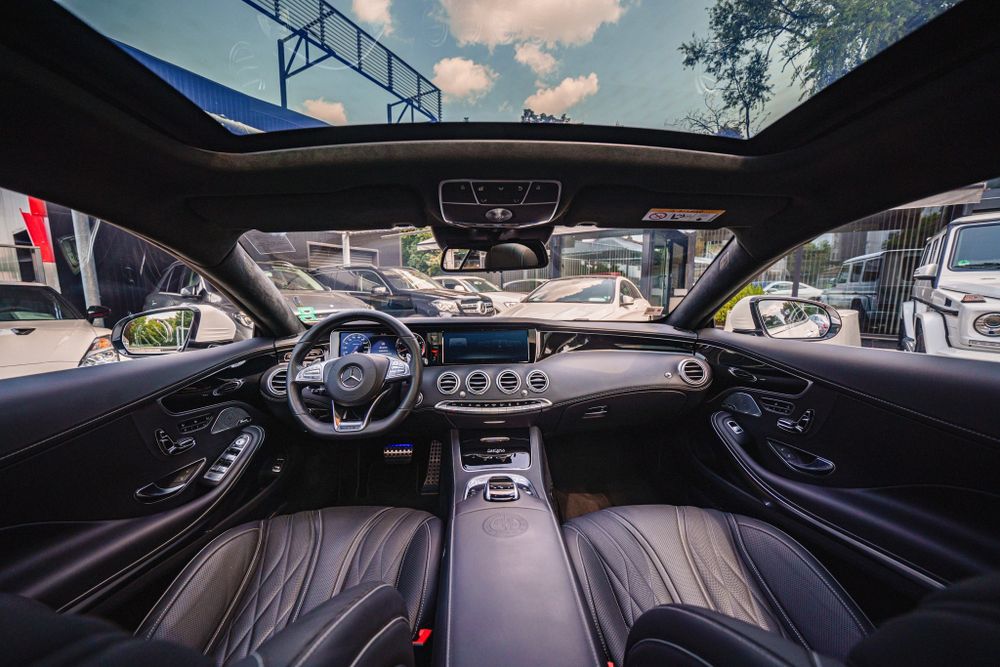 Mercedes-Benz luxury coupe interior showing digital dashboard and leather trim.
