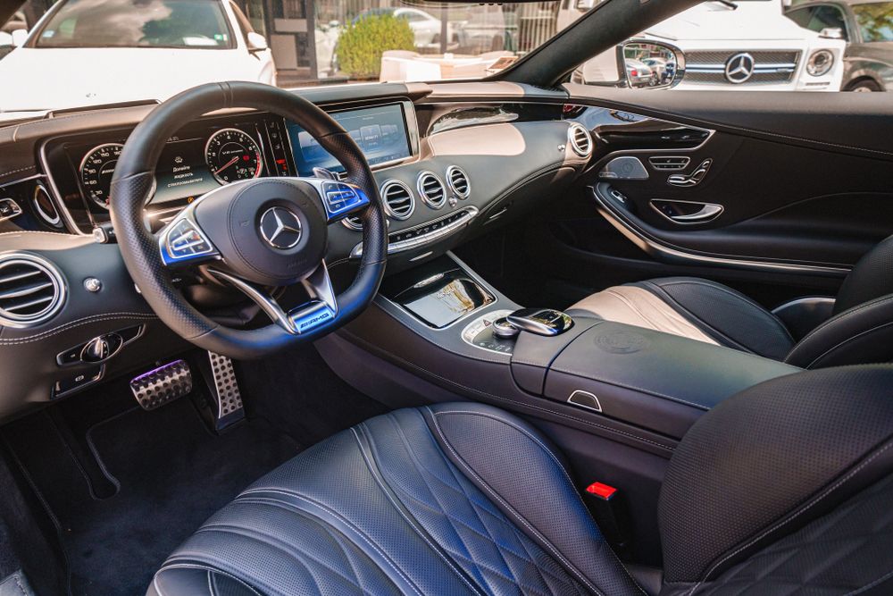 Modern Mercedes-Benz cockpit featuring leather seats and digital instrument cluster.