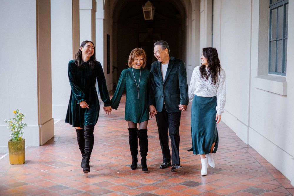 Candid walking shots in a Spanish colonial style corridor with arched walkways.