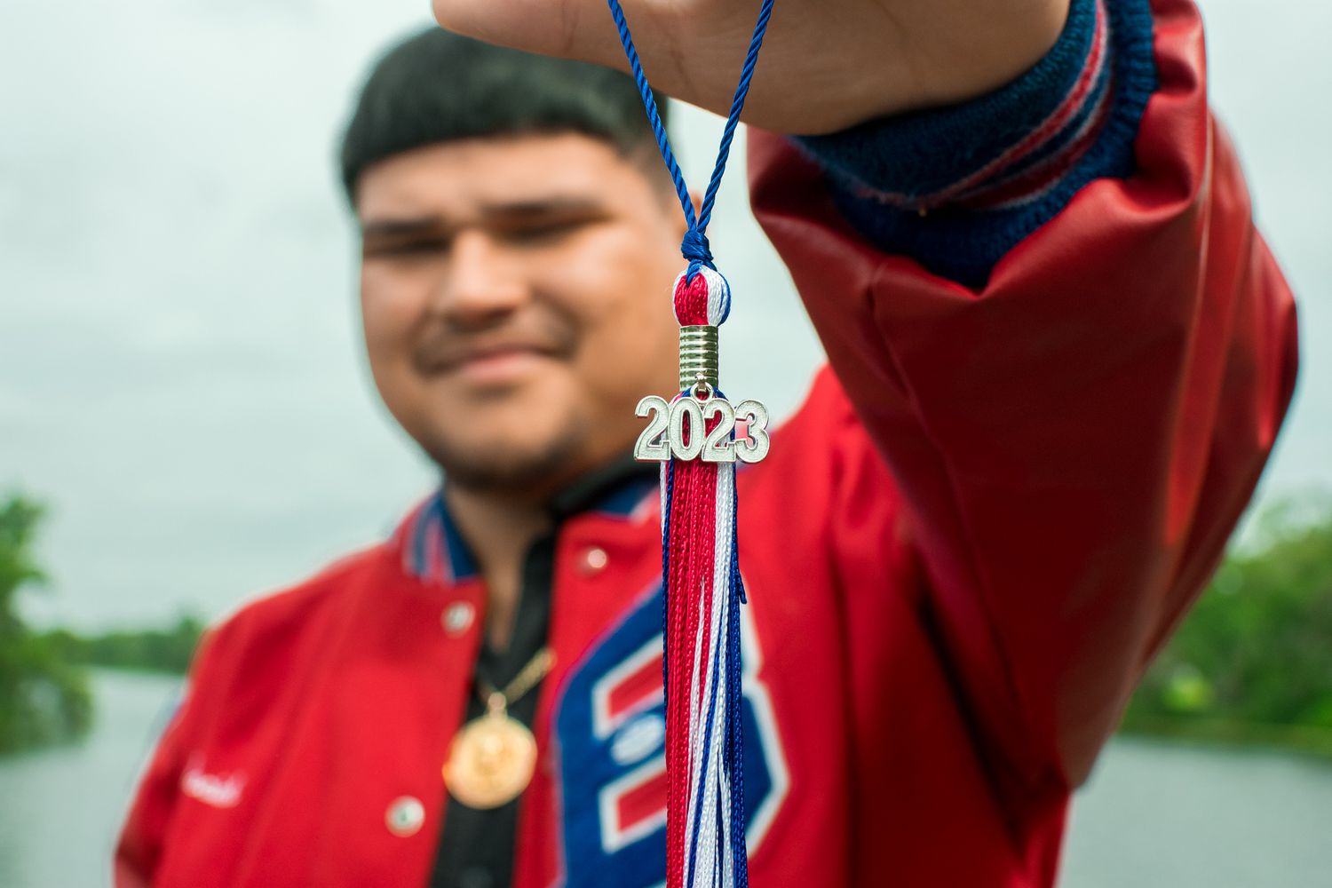 Close-up of a graduation tassel charm showing class of 2023 against a blurred background.