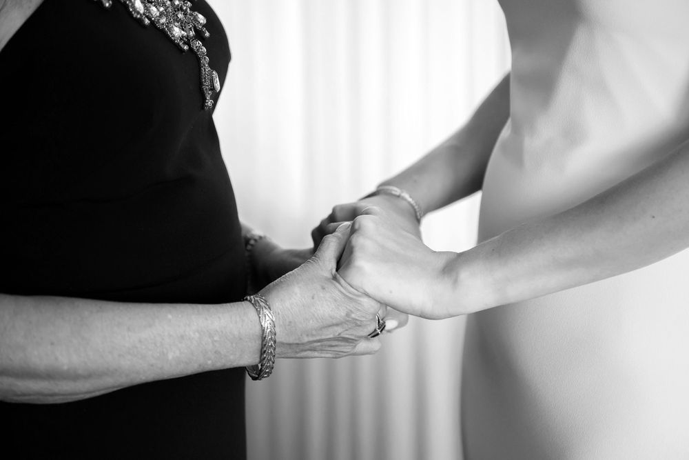 Bride holding mother's hands before wedding at InterContinental Cleveland photographed by Tom Forrest.