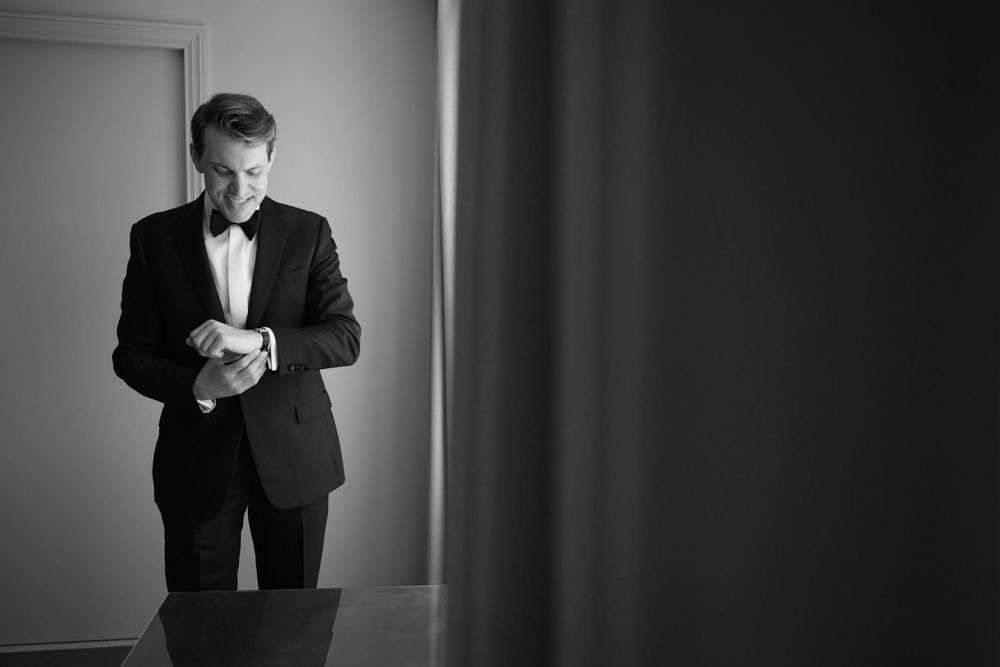 Groom adjusts cufflinks before wedding at InterContinental Cleveland photographed by Tom Forrest.