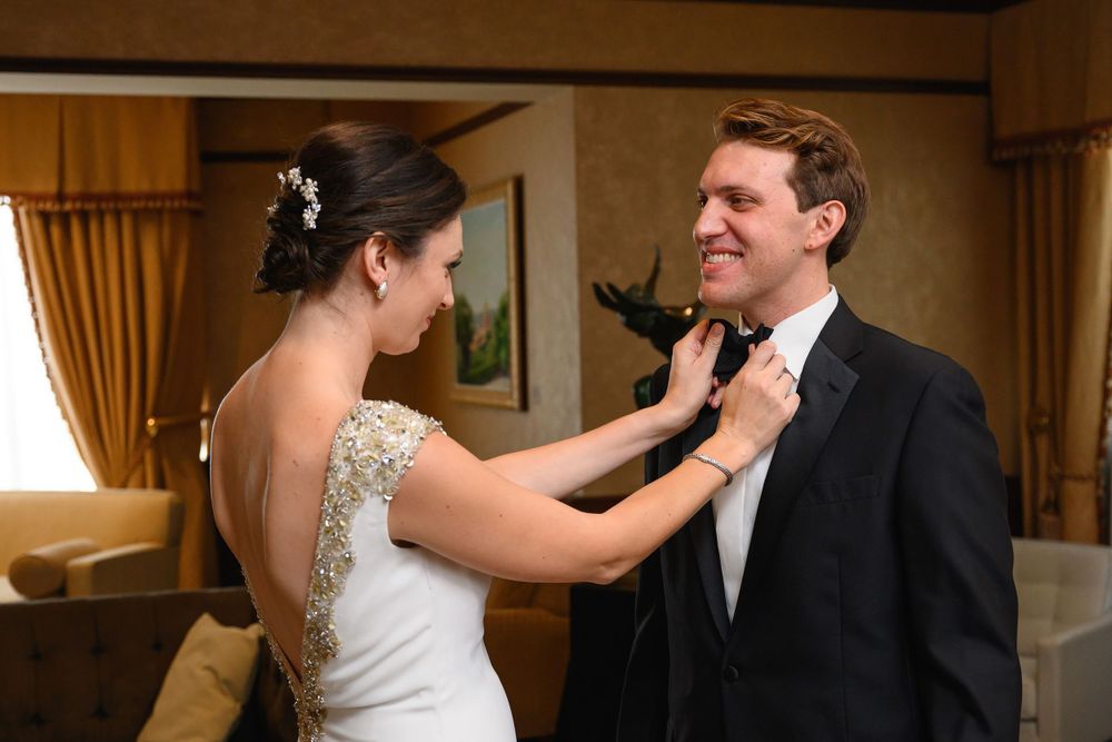 Bride adjusts groom's tie before wedding at InterContinental Cleveland photographed by Tom Forrest.