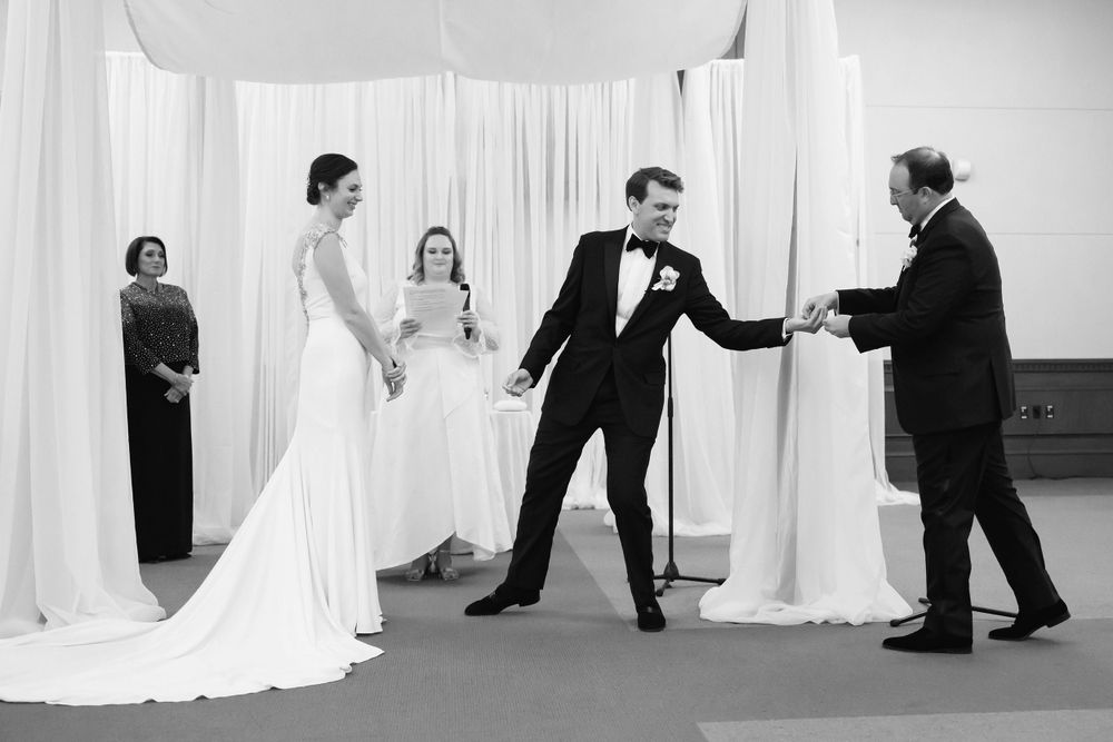 Groomsmen hands groom ring during wedding ceremony at InterContinental Cleveland photographed by Tom Forrest.