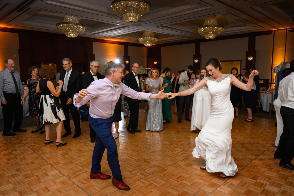 Bride and guest show off dance moves during wedding reception at InterContinental Cleveland photographed by Tom Forrest.