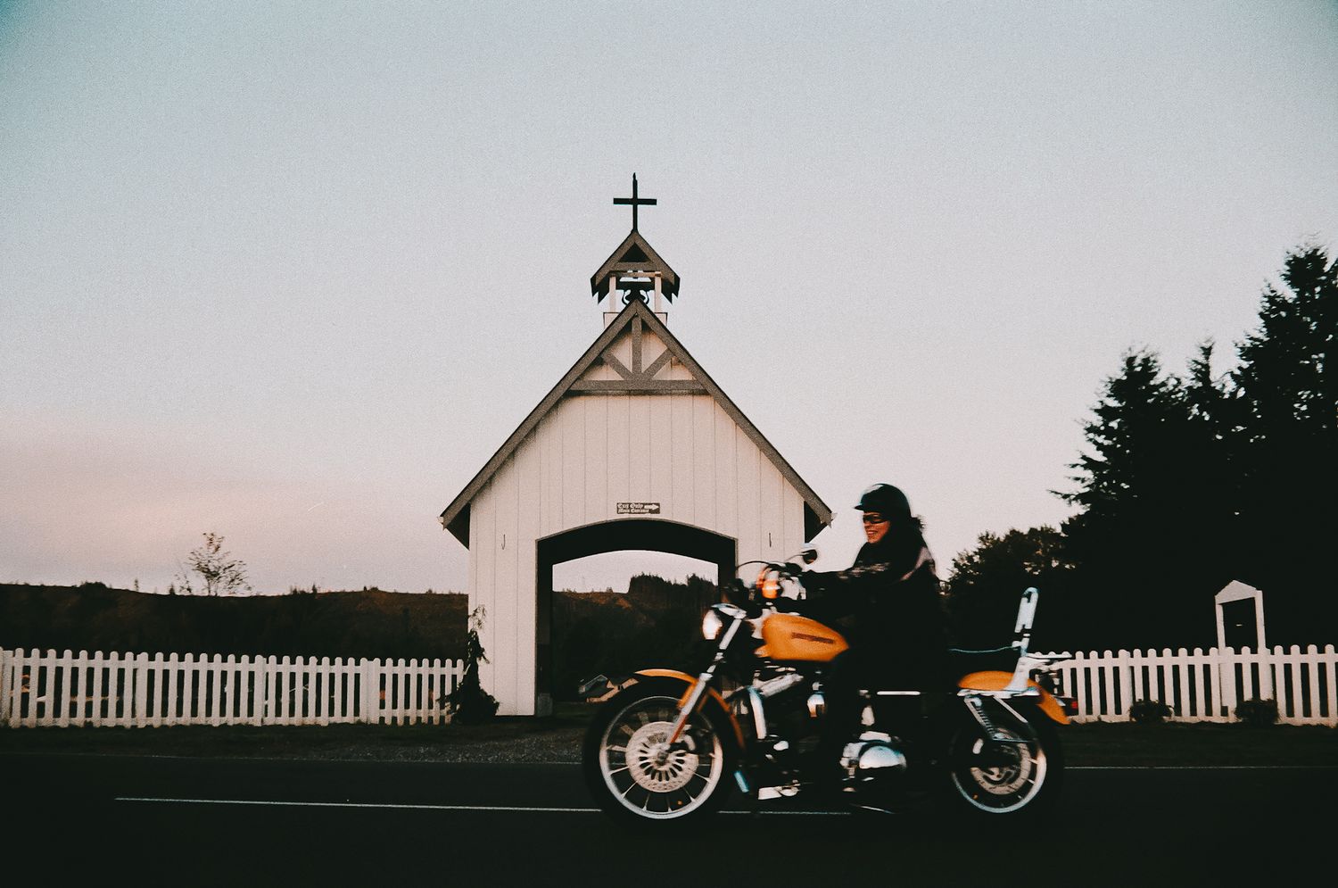 A motorcycle drives past a drive through chapel.