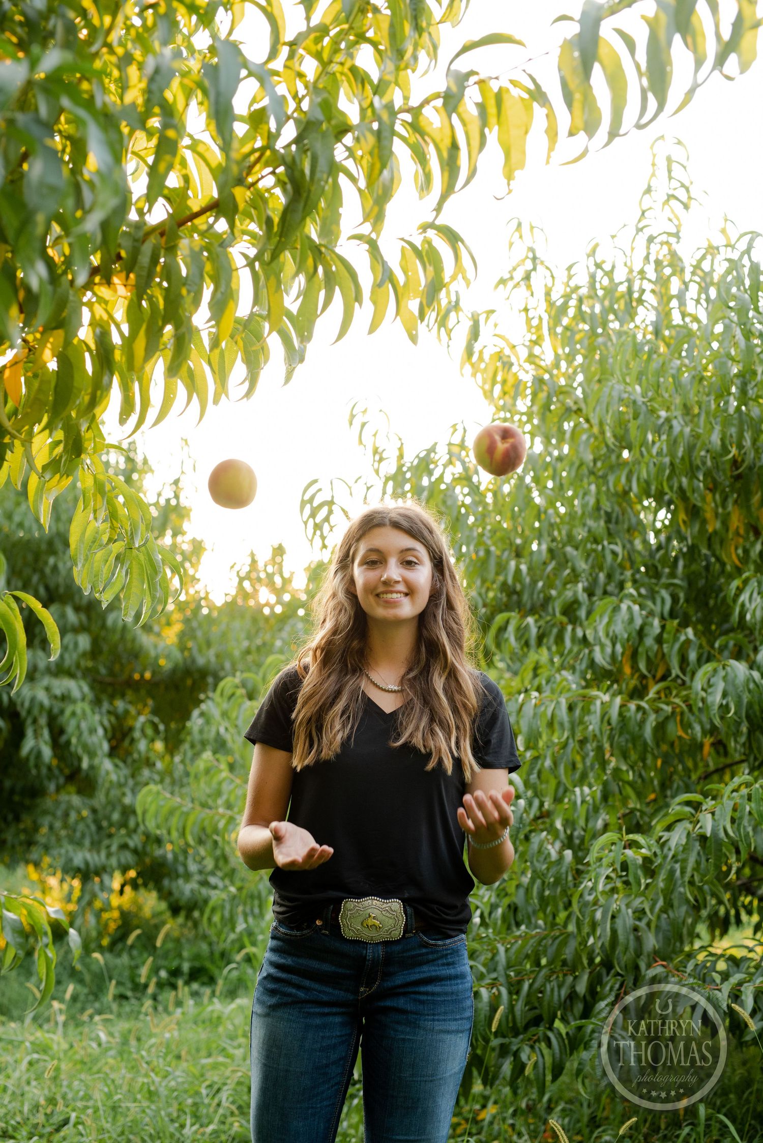 Someone juggling peaches in an orchard during golden hour with sunlight streaming through the leaves.