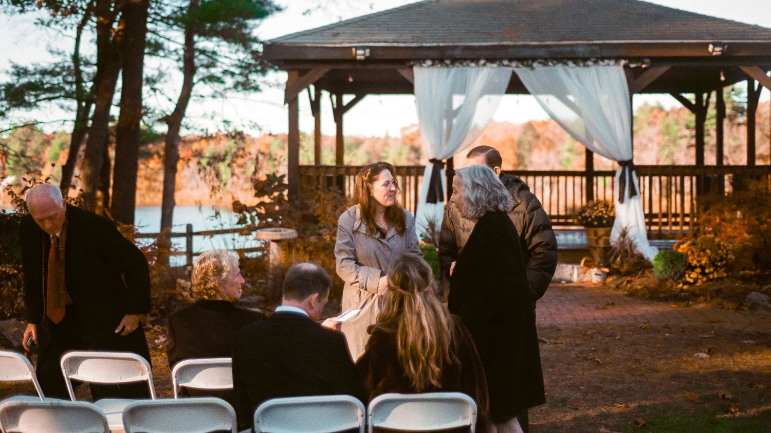 Outdoor wedding ceremony at a gazebo overlooking a scenic autumn landscape.