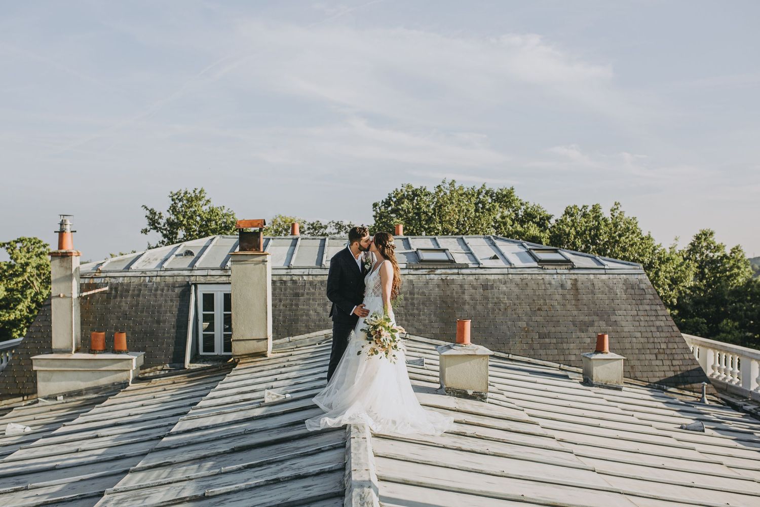 Scenic rooftop wedding photography session featuring white skylights and stone walls.