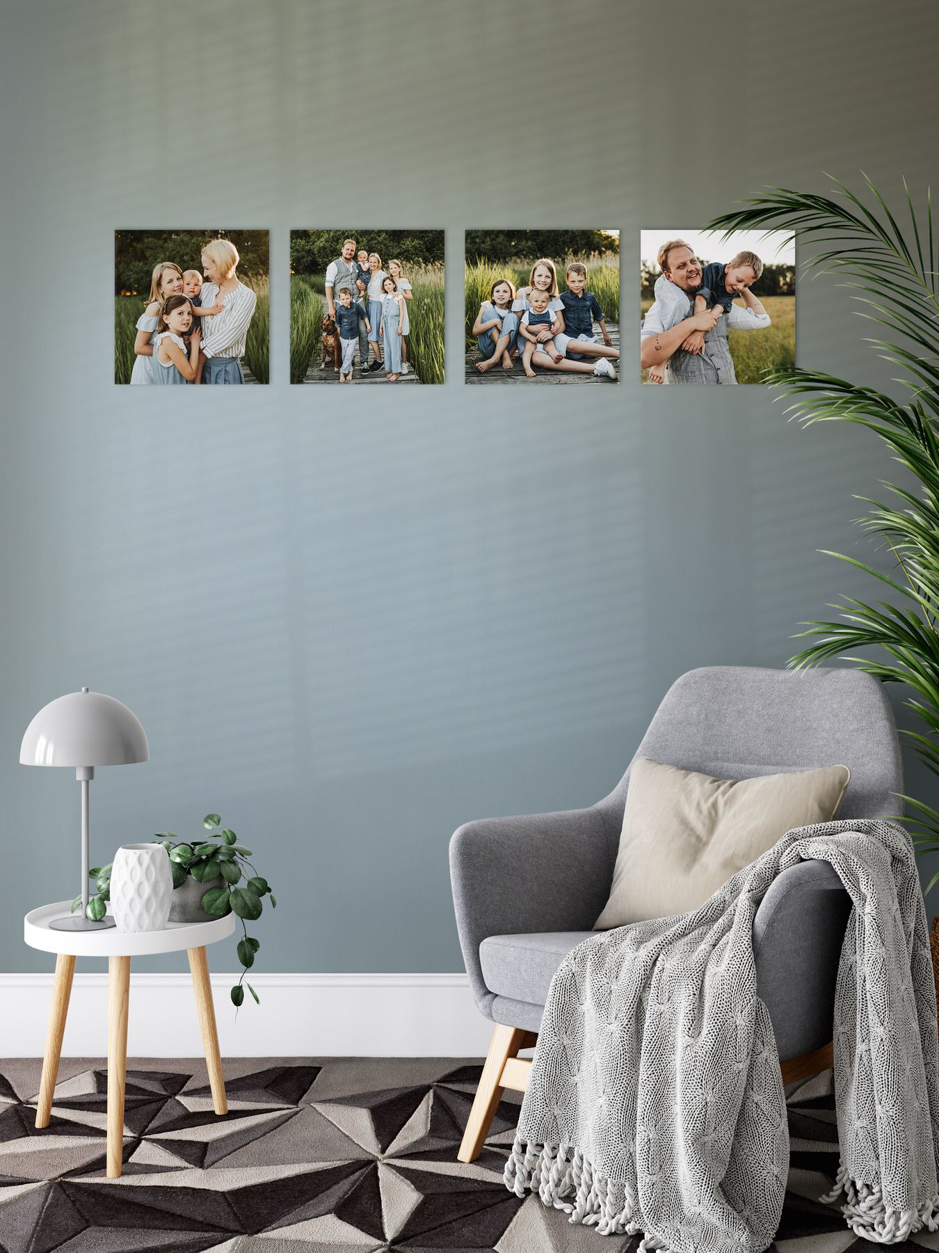 Vier Familienfotos in einer Reihe auf einer grauen Wand über modernen Wohnzimmermöbeln angeordnet.