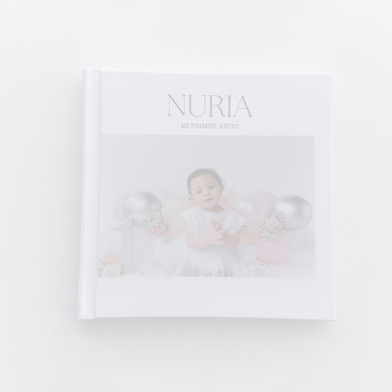 Clean white photo album cover featuring minimal text and soft baby portrait.