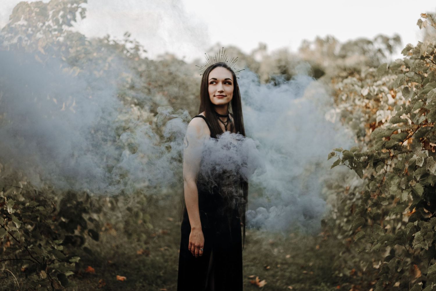 Moody portrait session with smoke bombs creating atmospheric effect outdoors.