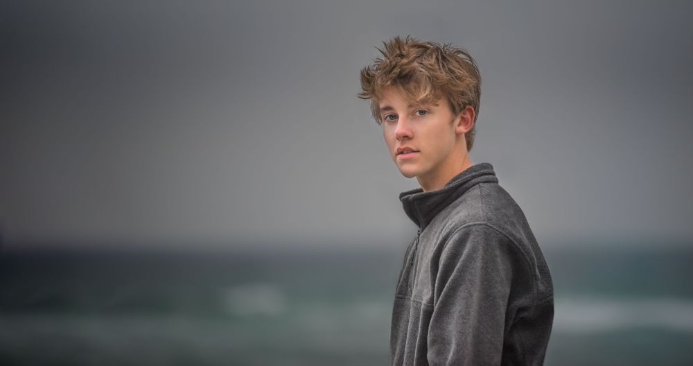 senior boy at beach in Destin florida by ocean