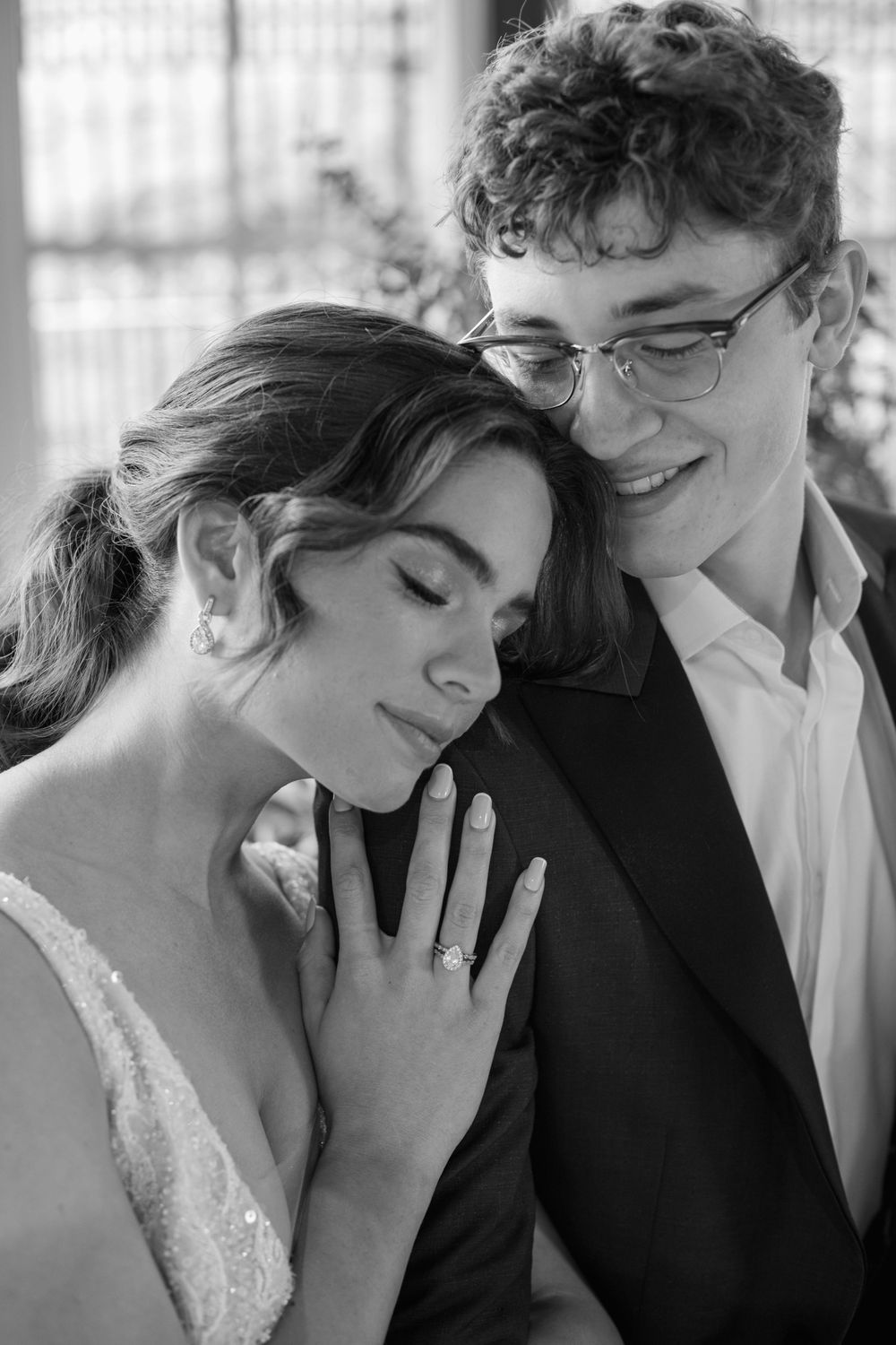 Black and white romantic wedding portrait showing tender moment between newlyweds.
