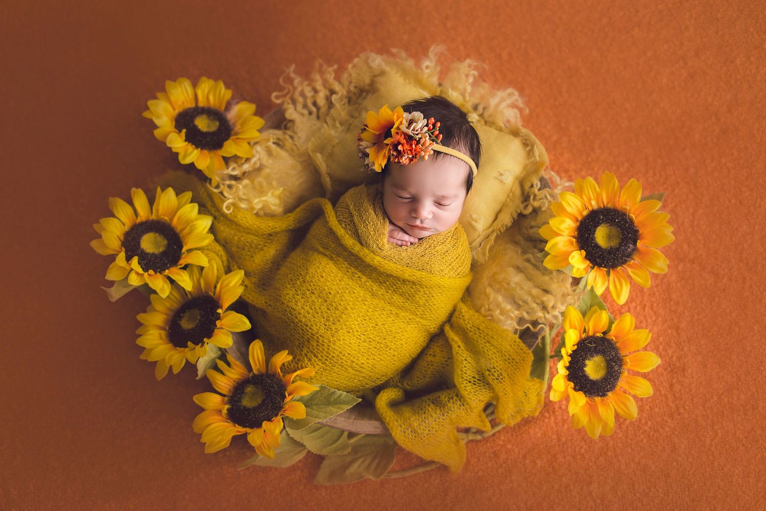 fotografa infantil bebe recien nacida en canasta rodeada por girasoles envuelta en amarillo
