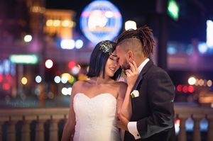 Romantic nighttime wedding portrait with Las Vegas city lights in the background.